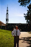 Bryan standing in front of Saturn V rocket.