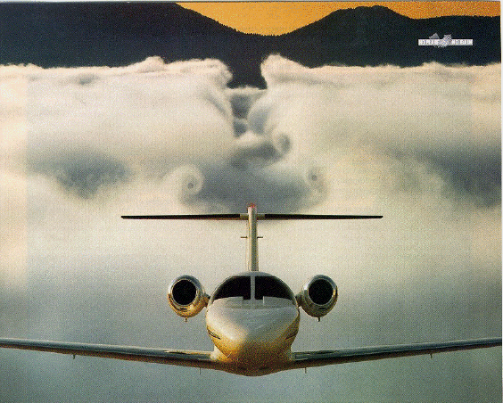 Photo of an airplane climbing through a cloud bank showing
 the result of downwash and tip vortices.