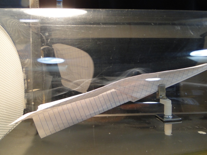 Photographs of paper airplane model in a wind tunnel using smoke
 flow visualization techniques.
